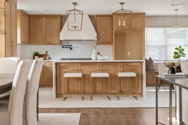 2906 Riata Ln, Houston, TX 77043 - kitchen featuring stovetop, custom exhaust hood, pendant lighting, light countertops, and tasteful backsplash