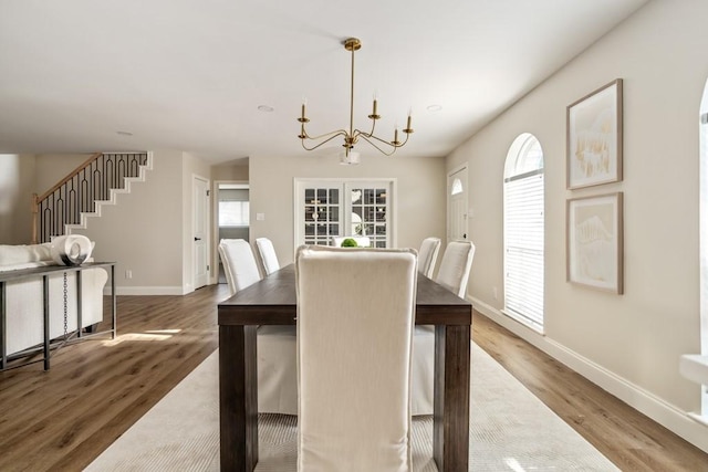 2906 Riata Ln, Houston, TX 77043 - dining space featuring wood finished floors, baseboards, a chandelier, and stairway