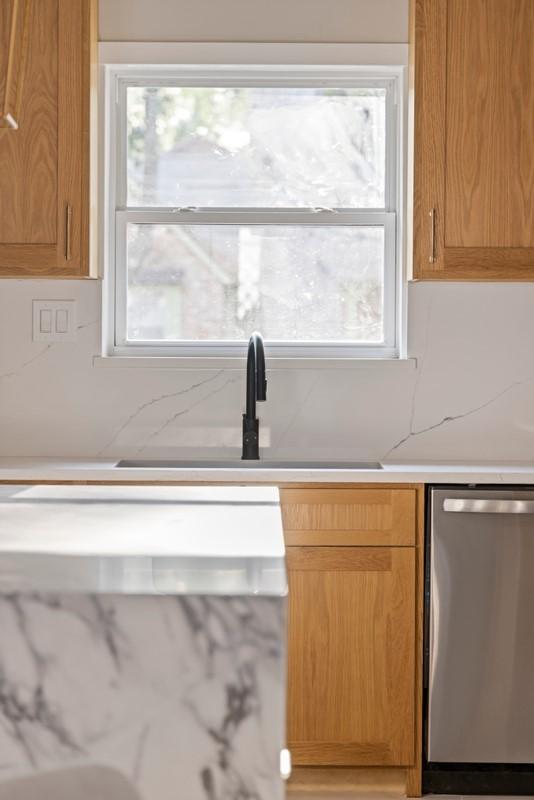 2906 Riata Ln, Houston, TX 77043 - kitchen with stainless steel dishwasher, light countertops, and a sink