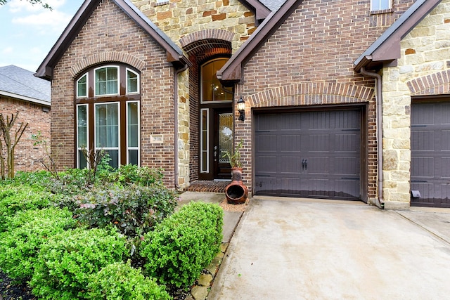 29306 Lovegrass Ct, Katy, TX 77494 - property entrance featuring concrete driveway, an attached garage, brick siding, and stone siding