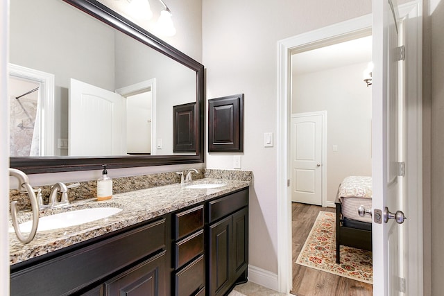 29306 Lovegrass Ct, Katy, TX 77494 - bathroom with double vanity, baseboards, connected bathroom, and wood finished floors