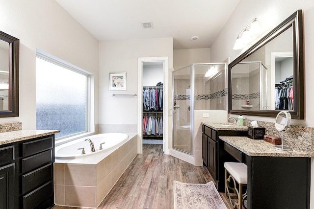 29306 Lovegrass Ct, Katy, TX 77494 - full bath featuring a walk in closet, vanity, a shower stall, a garden tub, and wood finished floors