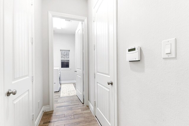 29306 Lovegrass Ct, Katy, TX 77494 - hall with washer and dryer, wood finished floors, and baseboards