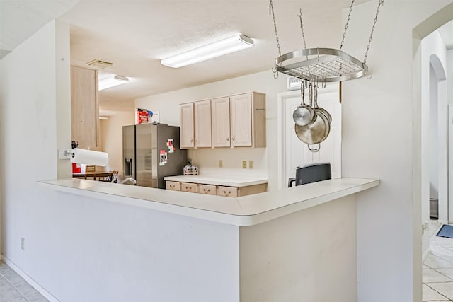 4934 Parkcrest Dr, La Porte, TX 77571 - kitchen featuring stainless steel fridge, a peninsula, light brown cabinetry, and light tile patterned flooring