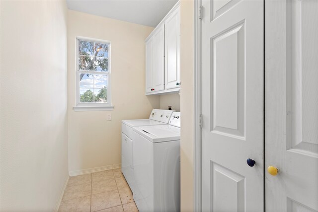 7903 S Wellington Ct, Houston, TX 77055 - washroom featuring cabinet space, washing machine and dryer, baseboards, and light tile patterned floors