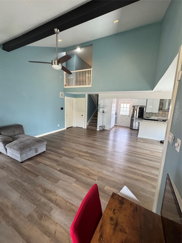 20806 Park Ridge Ct, Katy, TX 77450 - unfurnished living room featuring high vaulted ceiling, stairway, beamed ceiling, ceiling fan, and wood finished floors