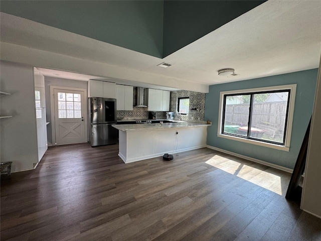 20806 Park Ridge Ct, Katy, TX 77450 - kitchen with freestanding refrigerator, wall chimney exhaust hood, a peninsula, white cabinetry, and dark wood-style flooring
