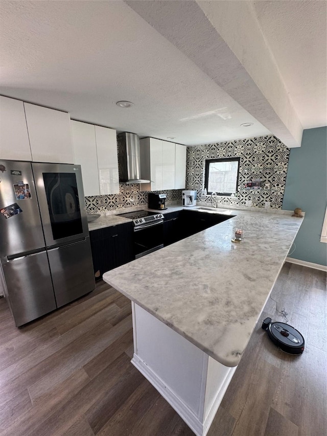 20806 Park Ridge Ct, Katy, TX 77450 - kitchen featuring stainless steel appliances, wall chimney exhaust hood, a peninsula, dark wood finished floors, and light countertops