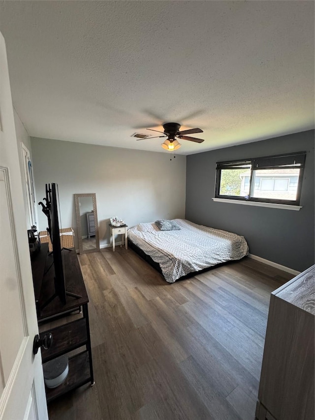 20806 Park Ridge Ct, Katy, TX 77450 - bedroom with a textured ceiling, dark wood-style floors, baseboards, and a ceiling fan