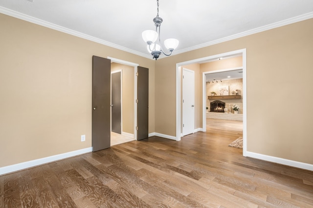 7 E Torch Pine Cir, The Woodlands, TX 77381 - spare room with baseboards, a chandelier, wood finished floors, and crown molding