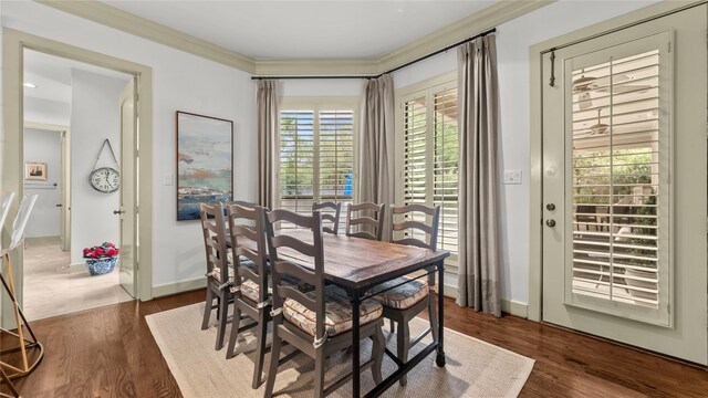 5558 Aspen St, Bellaire, TX 77401 - dining space with crown molding, dark wood-style flooring, and baseboards