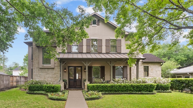 5558 Aspen St, Bellaire, TX 77401 - view of front of home featuring stone siding, a standing seam roof, covered porch, and metal roof