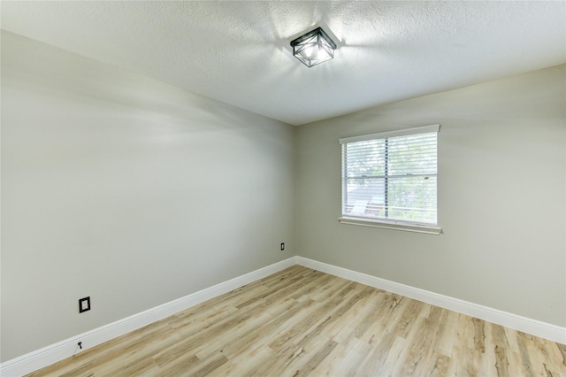 13727 Sablegarden Ln, Houston, TX 77014 - spare room with light wood-style floors, baseboards, and a textured ceiling