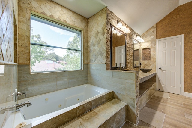 13727 Sablegarden Ln, Houston, TX 77014 - bathroom with a jetted tub, vaulted ceiling, wood finished floors, and vanity