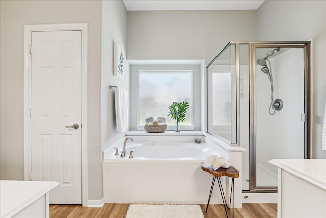 12427 Adams Ridge Ln, Humble, TX 77346 - bathroom featuring vanity, a shower stall, a garden tub, and wood finished floors