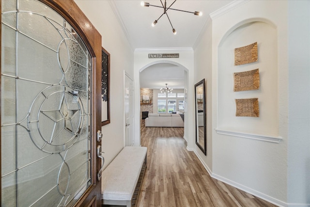 12427 Adams Ridge Ln, Humble, TX 77346 - entryway featuring a chandelier, wood finished floors, ornamental molding, arched walkways, and baseboards