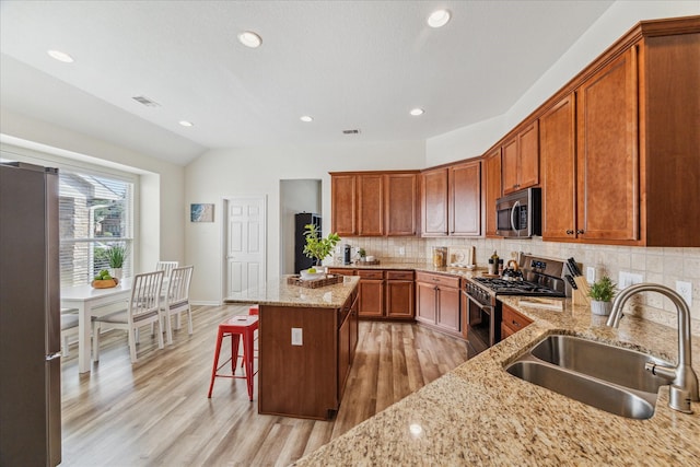 12427 Adams Ridge Ln, Humble, TX 77346 - kitchen featuring a sink, stainless steel appliances, light wood-style floors, a center island, and vaulted ceiling