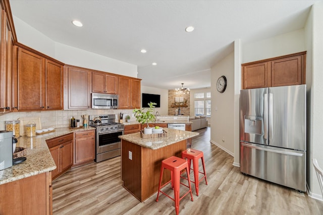 12427 Adams Ridge Ln, Humble, TX 77346 - kitchen featuring appliances with stainless steel finishes, backsplash, light wood-style flooring, light stone counters, and recessed lighting