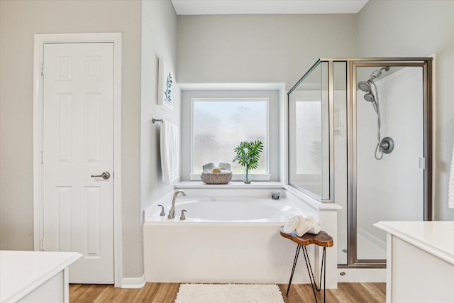 12427 Adams Ridge Ln, Humble, TX 77346 - full bath featuring vanity, a stall shower, a garden tub, and wood finished floors