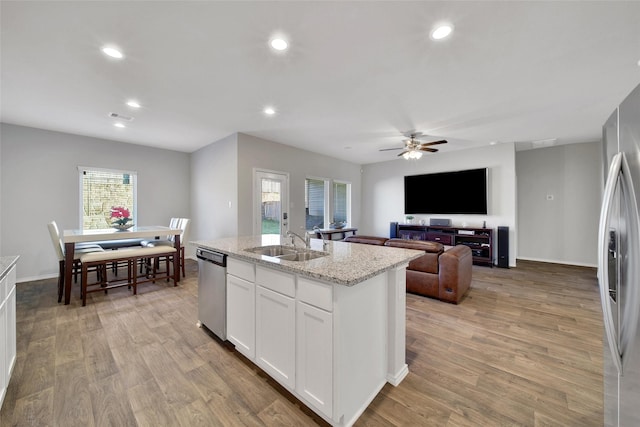 13854 Rock Island Trl, Conroe, TX 77384 - kitchen featuring a sink, appliances with stainless steel finishes, recessed lighting, light wood finished floors, and white cabinets