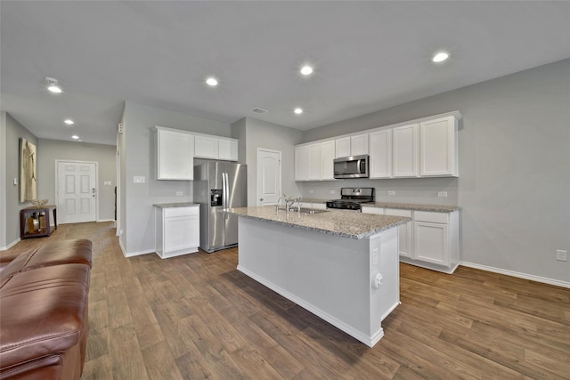 13854 Rock Island Trl, Conroe, TX 77384 - kitchen with appliances with stainless steel finishes, baseboards, dark wood-style floors, white cabinets, and recessed lighting