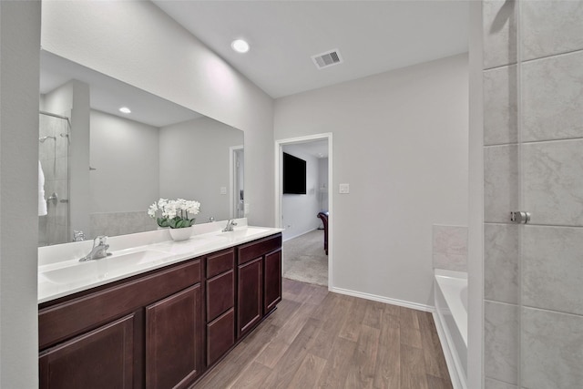 13854 Rock Island Trl, Conroe, TX 77384 - full bath featuring wood finished floors, a garden tub, double vanity, and a shower