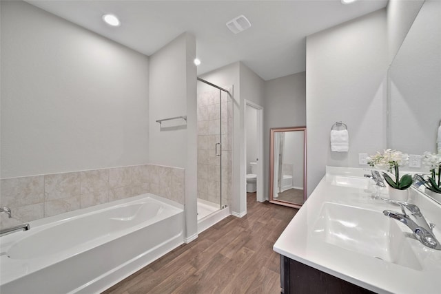 13854 Rock Island Trl, Conroe, TX 77384 - bathroom featuring toilet, a bath, a stall shower, double vanity, and wood finished floors