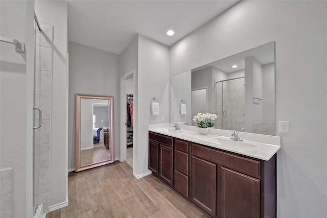 13854 Rock Island Trl, Conroe, TX 77384 - full bath with a shower stall, wood finished floors, a walk in closet, double vanity, and baseboards