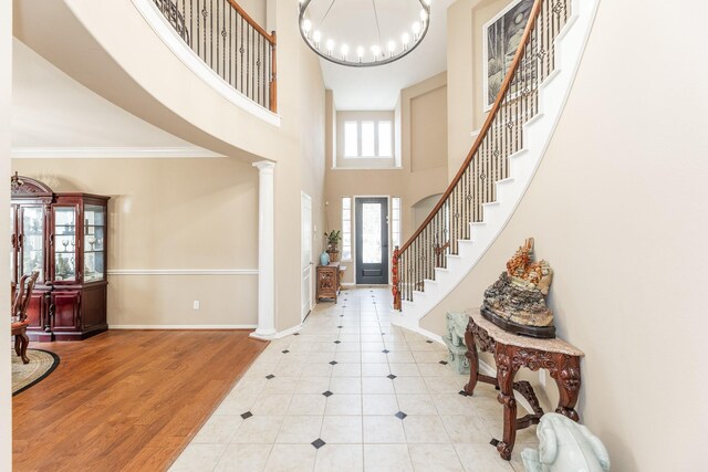 13422 Great Creek Dr, Pearland, TX 77584 - tiled entrance foyer featuring stairs, a chandelier, a towering ceiling, baseboards, and ornate columns