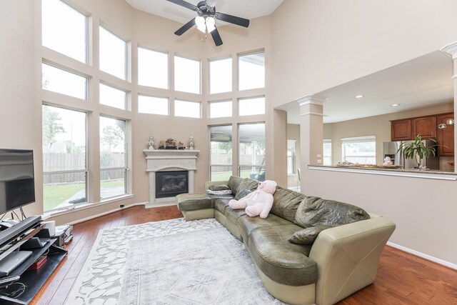 13422 Great Creek Dr, Pearland, TX 77584 - living room with ceiling fan, plenty of natural light, ornate columns, hardwood / wood-style flooring, and a towering ceiling