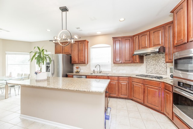 13422 Great Creek Dr, Pearland, TX 77584 - kitchen with stainless steel appliances, under cabinet range hood, a sink, light tile patterned floors, and recessed lighting