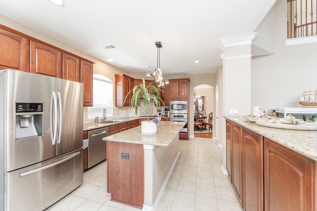 13422 Great Creek Dr, Pearland, TX 77584 - kitchen with appliances with stainless steel finishes, arched walkways, a sink, light tile patterned flooring, and recessed lighting