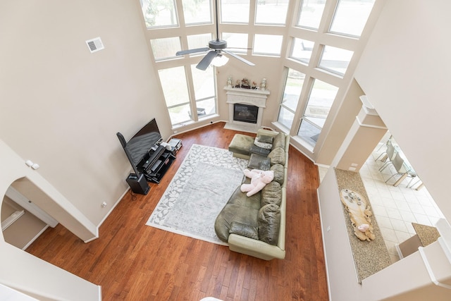 13422 Great Creek Dr, Pearland, TX 77584 - living room with a fireplace, wood finished floors, a ceiling fan, a high ceiling, and baseboards