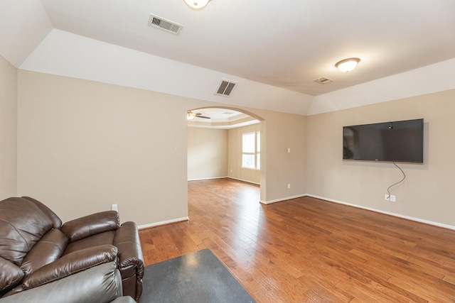 13422 Great Creek Dr, Pearland, TX 77584 - living room featuring arched walkways, wood finished floors, baseboards, and vaulted ceiling