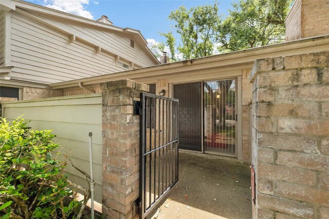2711 Grants Lake Blvd Unit 144, Sugar Land, TX 77479 - doorway to property featuring brick siding and a gate