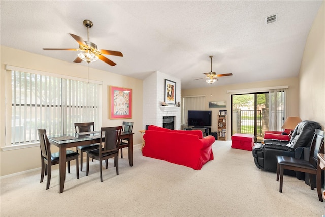 2711 Grants Lake Blvd Unit 144, Sugar Land, TX 77479 - living area featuring ceiling fan, carpet flooring, a brick fireplace, a textured ceiling, and baseboards