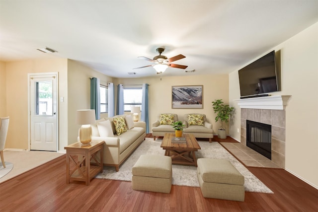 19426 Dolan Springs Dr, Tomball, TX 77377 - living room with wood finished floors, a tile fireplace, ceiling fan, and baseboards