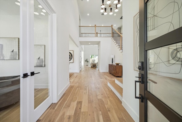 1707 Nina Lee Ln, Houston, TX 77018 - foyer with light wood-style flooring, stairs, a high ceiling, a chandelier, and baseboards