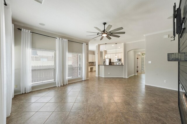 527 Oak Ridge Grove Cir, Spring, TX 77386 - unfurnished living room with ceiling fan, crown molding, arched walkways, tile patterned floors, and baseboards