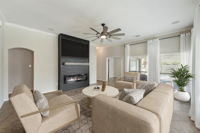 527 Oak Ridge Grove Cir, Spring, TX 77386 - tiled living area with ornamental molding, a ceiling fan, a fireplace, arched walkways, and baseboards