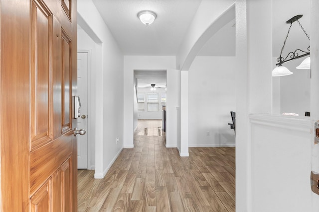 9931 Chimney Swift Ln, Conroe, TX 77385 - hall with arched walkways, light wood-type flooring, and baseboards