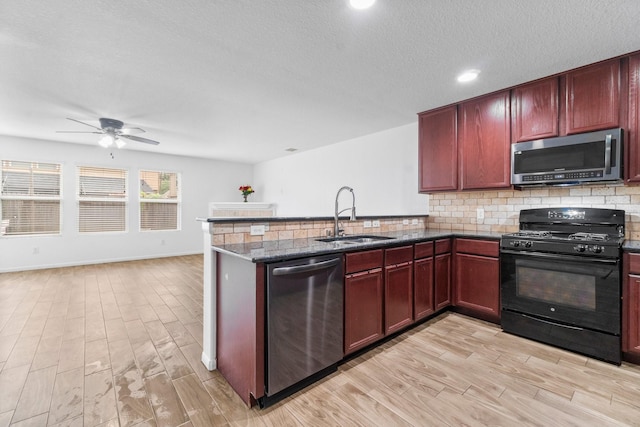 9931 Chimney Swift Ln, Conroe, TX 77385 - kitchen with stainless steel appliances, a sink, reddish brown cabinets, tasteful backsplash, and a textured ceiling