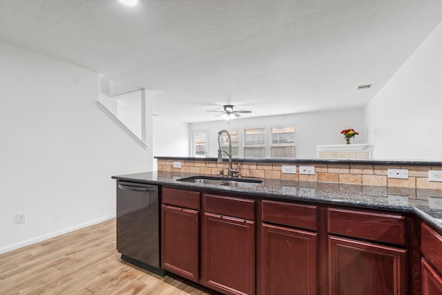 9931 Chimney Swift Ln, Conroe, TX 77385 - kitchen with dishwashing machine, reddish brown cabinets, a sink, dark stone countertops, and decorative backsplash