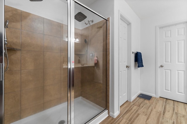 9931 Chimney Swift Ln, Conroe, TX 77385 - full bathroom featuring a stall shower, wood finished floors, and baseboards