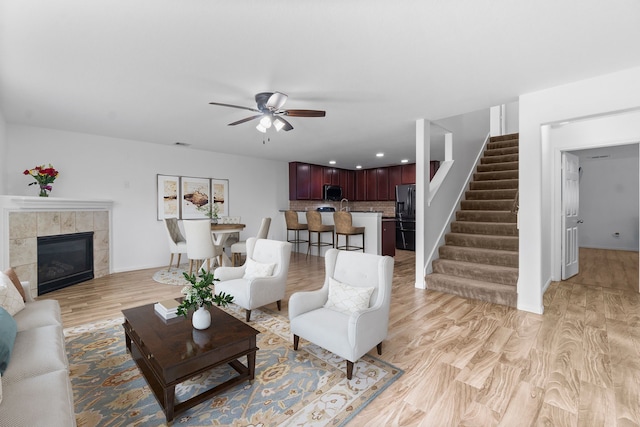 9931 Chimney Swift Ln, Conroe, TX 77385 - living room with stairway, ceiling fan, light wood-style floors, a fireplace, and recessed lighting