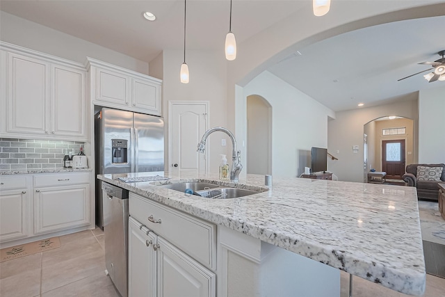 16742 Highland Country Dr, Cypress, TX 77433 - kitchen with a sink, arched walkways, stainless steel appliances, white cabinetry, and open floor plan