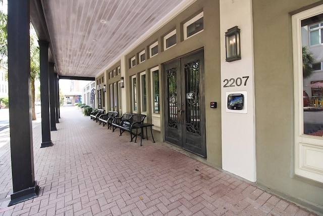2207 Postoffice St Unit 208, Galveston, TX 77550 - view of exterior entry with french doors, stucco siding, and covered porch