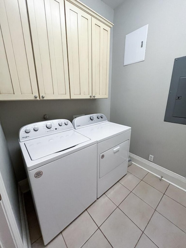 2207 Postoffice St Unit 208, Galveston, TX 77550 - washroom with electric panel, cabinet space, washing machine and clothes dryer, baseboards, and light tile patterned floors
