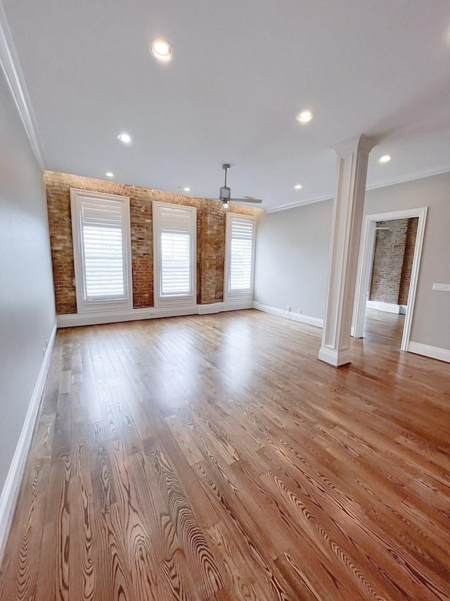 2207 Postoffice St Unit 208, Galveston, TX 77550 - unfurnished living room featuring baseboards, crown molding, light wood-style flooring, recessed lighting, and decorative columns