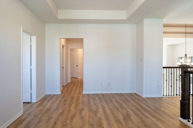 15842 Formaston Forest Dr, Humble, TX 77346 - empty room featuring wood finished floors, a chandelier, baseboards, and a tray ceiling